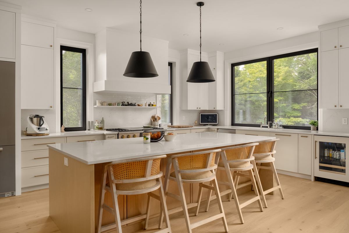 Chef's kitchen with a large island with seating and black pendant lights