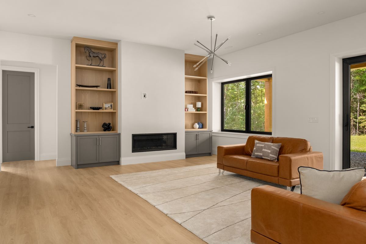 Finished lower level family room with built-ins and a linear fireplace