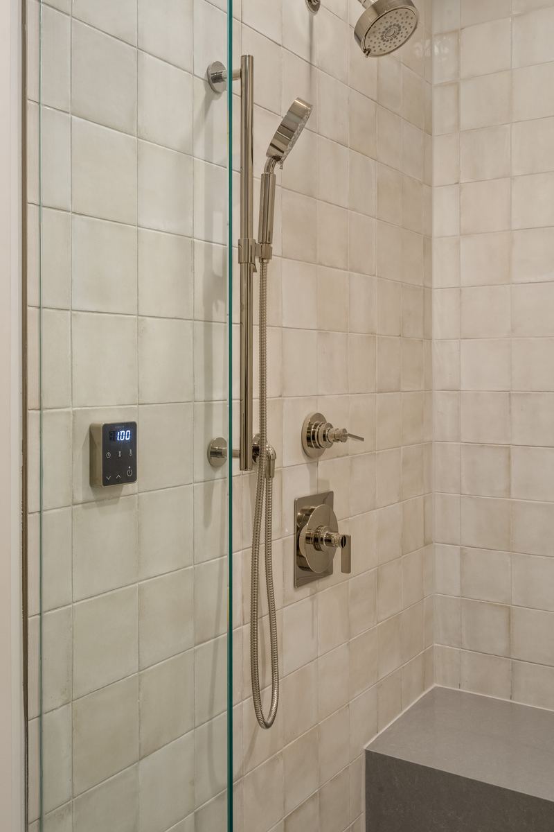 Second glass shower with tiled walls and a built-in bench