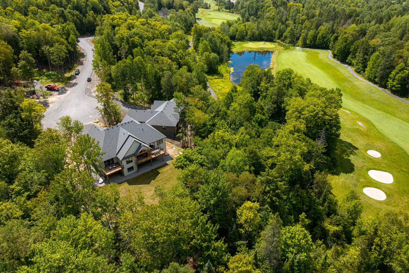 Aerial view of finished Fuller homes on Glen Eagle Court at Deerhurst Highlands, backing onto a fairway with bunkers and a pond