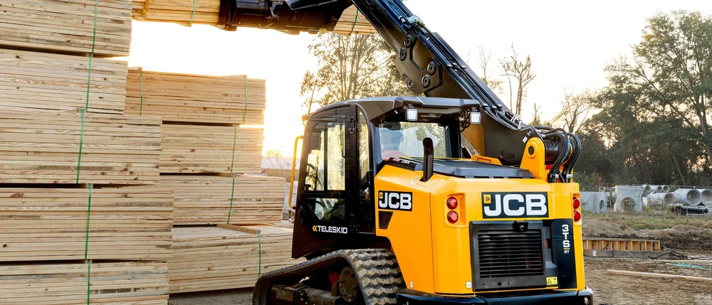JCB Teleskid telescopic compact track loader lifting a pack of lumber on a build site