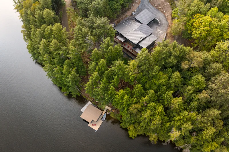 Aerial view of the finished Hemlock Point waterfront home, built by Fuller in mature hemlock forest above the lake