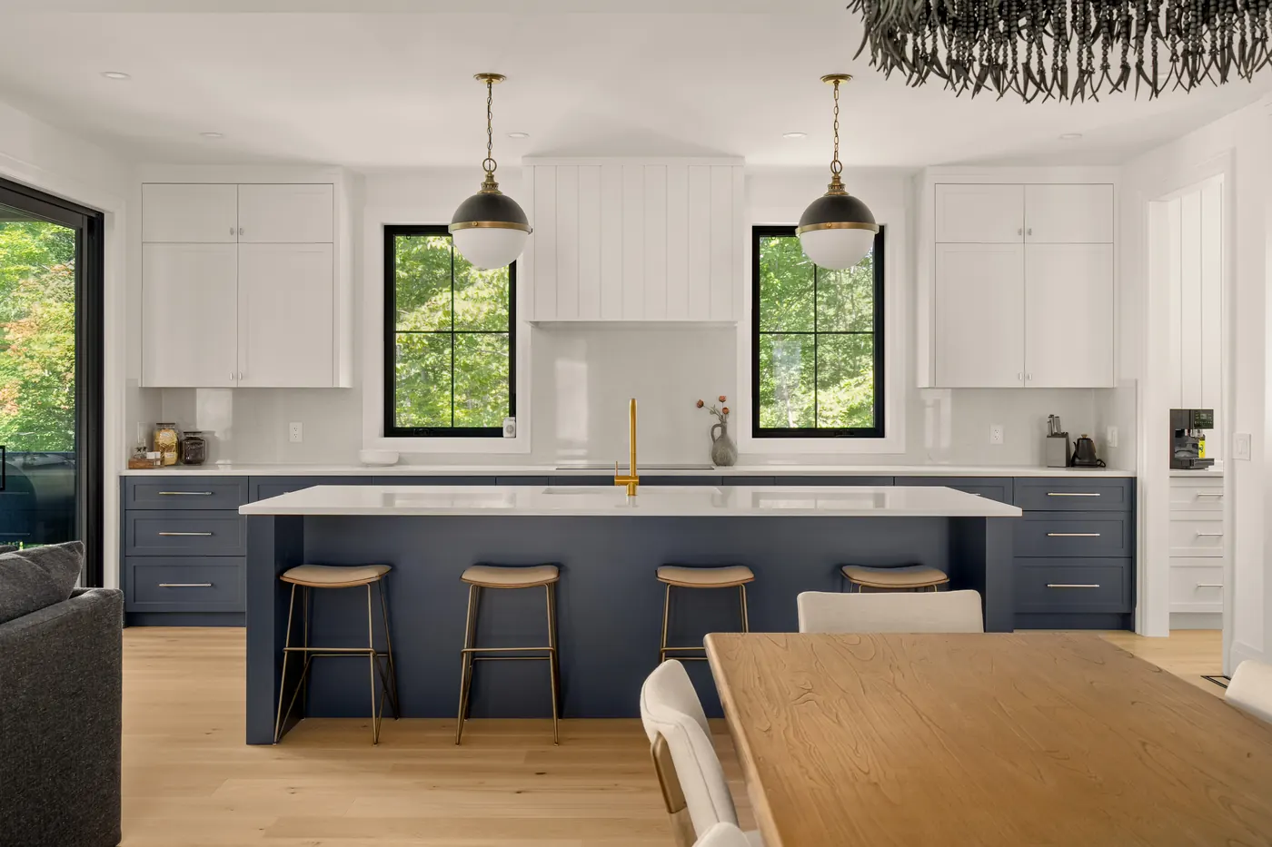 Kitchen straight on, navy island under brass pendant lights in the Fuller model home, 9 Glen Eagle Court