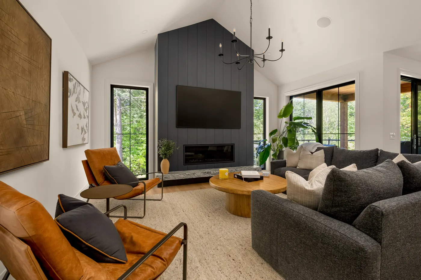 Living room with a dark shiplap fireplace wall under a vaulted ceiling in the Fuller model home, 9 Glen Eagle Court